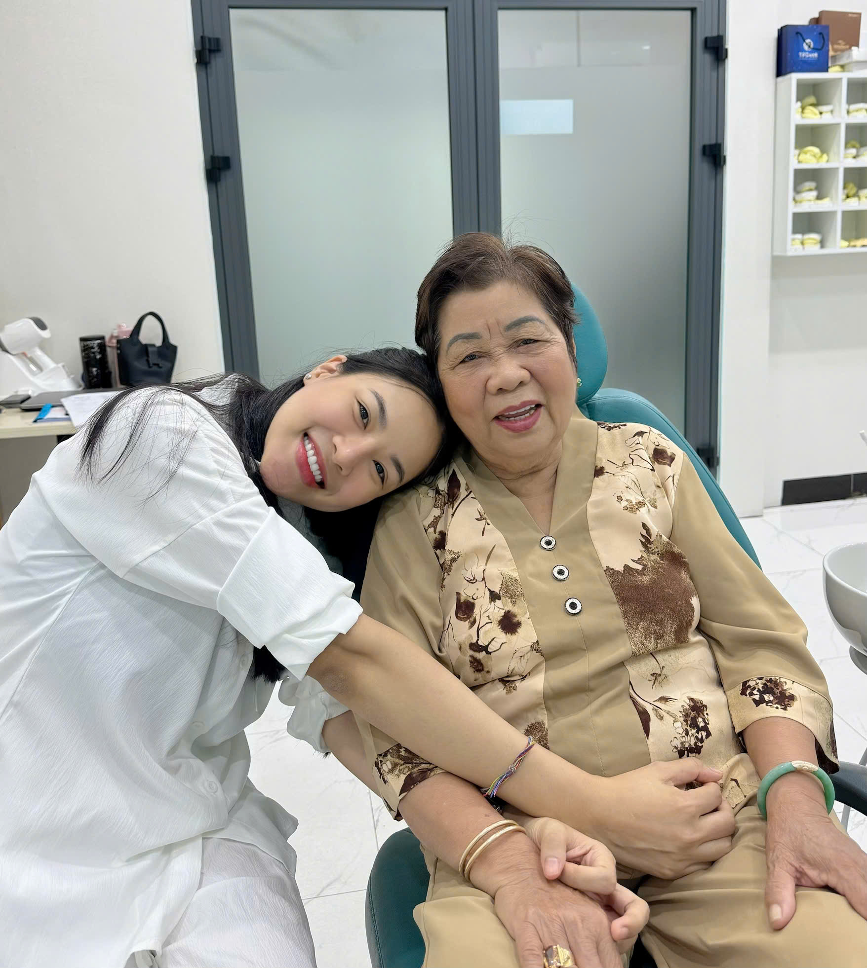 Chị Hà tựa đầu bên một cô lớn tuổi, cả hai cùng cười thật tươi trên ghế Nha khoa Nami